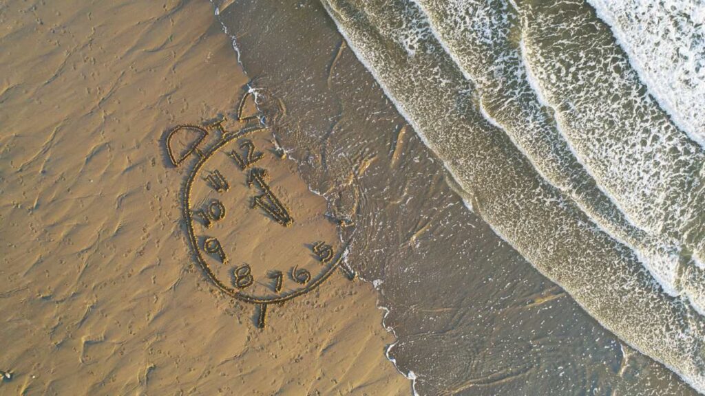 Uhr in Strandsand gemalt mit Wasser