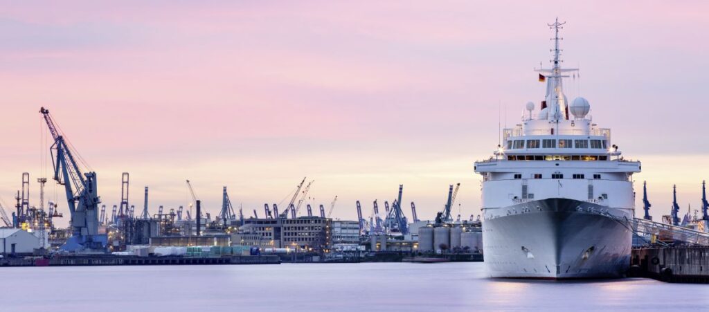 Panoramabild des Hamburger Hafens mit Werften und Kreuzfahrtschiff bei Sonnenuntergang