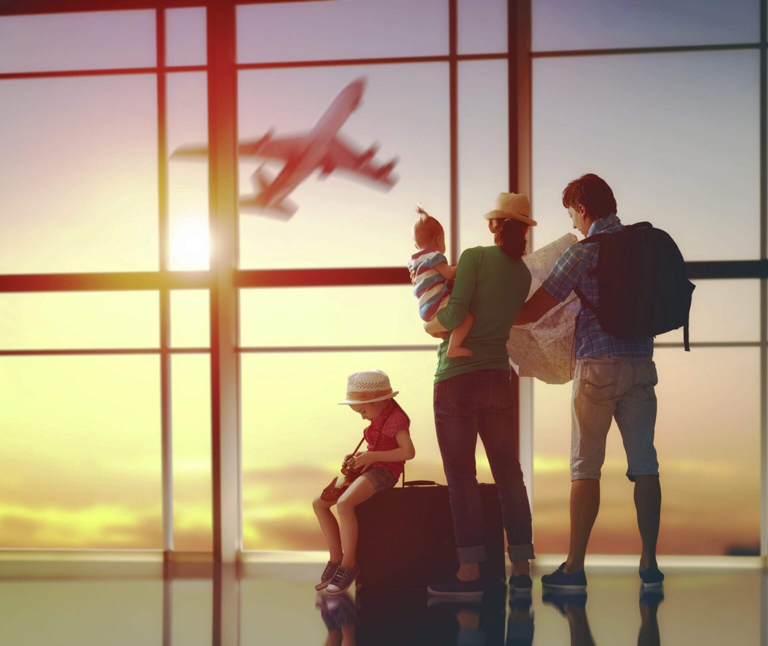Nachhaltigkeit macht im Urlaub oft Pause Familie am Flughafen mit Gepäck blickt auf Flugzeug auf Landebahn