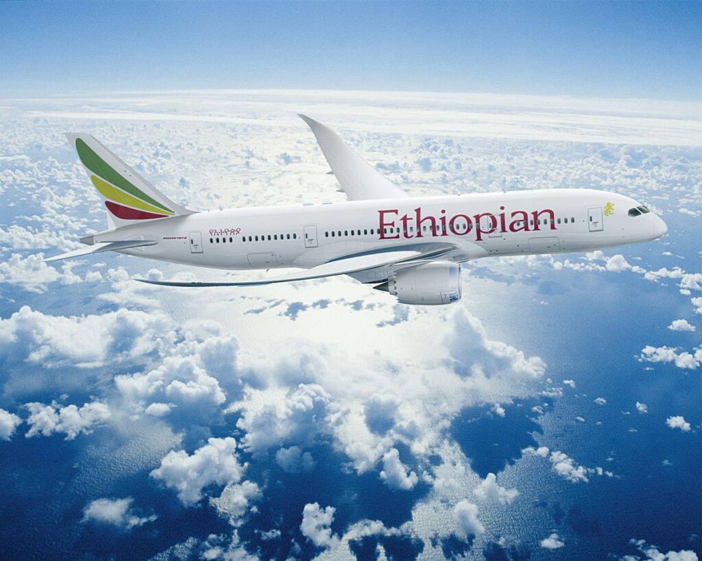Hier entsteht Afrikas größter Flughafen bis 2030 Ein Flugzeug der Ethiopian Airlines fliegt über eine Wolkendecke mit Blick auf den Ozean.