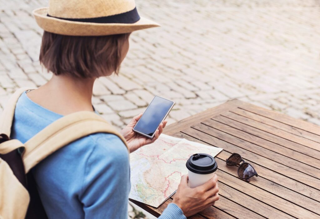 Clevere Urlaubshilfe bei Hitze: Diese Karte zeigt, wo Sie Schatten finden Urlauberin mit Handy