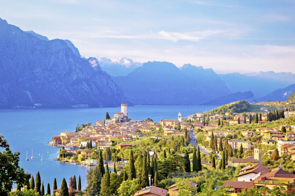 Raubfisch-Alarm am Gardasee: Italien investiert 100.000 Euro gegen Riesenwelse Panororamasicht auf den Gardasee mit der Stadt Malcesine am Ostufer.