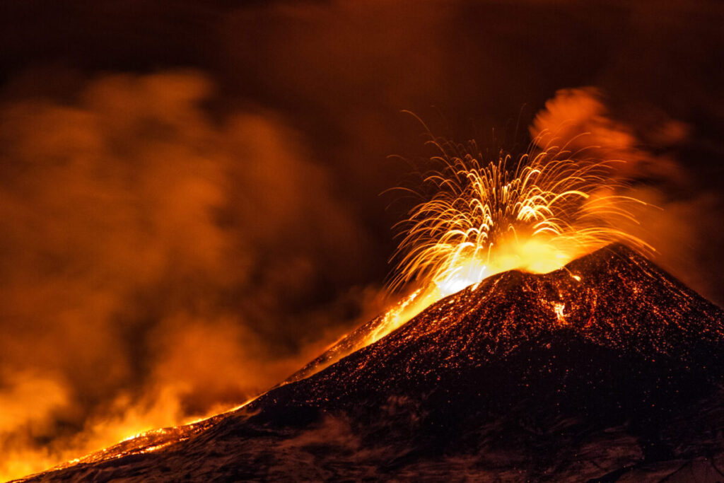 Der Vulkan Ätna spuckt leuchtendrote Lava in der Dunkelheit
