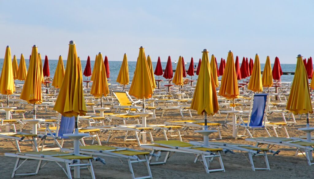 Italien-Urlaub im Wandel: Mehr kostenlose Strände für Badegäste geplant Privates Strandbad mit Liegen und zugeklappten Sonnenschirmen in Italien