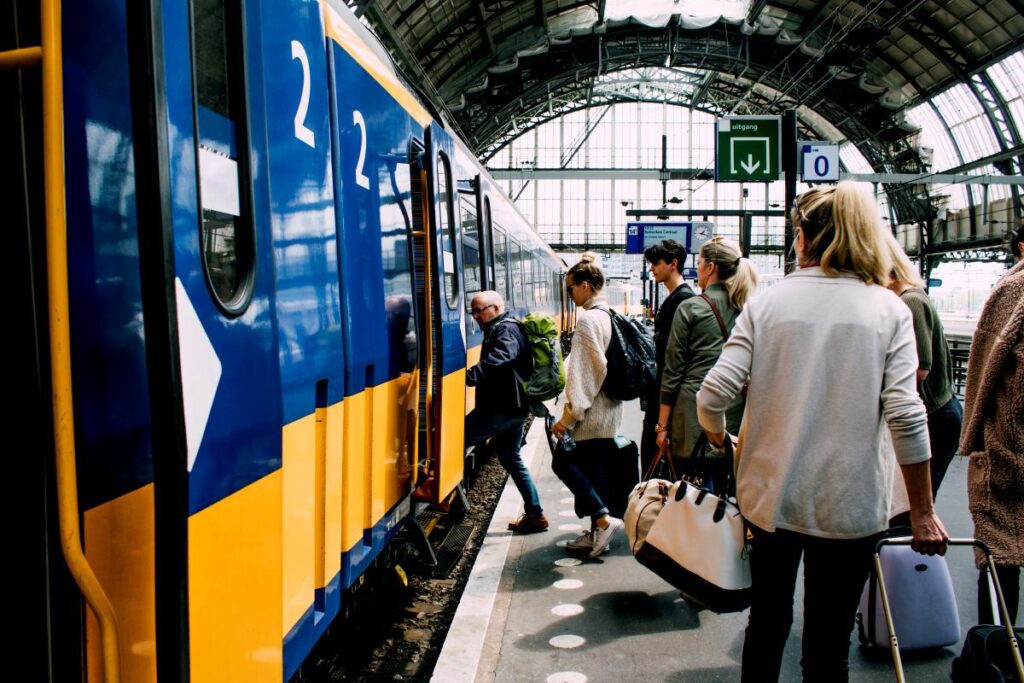 Niederlande vor 24-Stunden-Streik: Was am 9. September auf Reisende zukommt Reisende steigen in einen Zug am Bahnhof Amsterdam in den Niederlanden