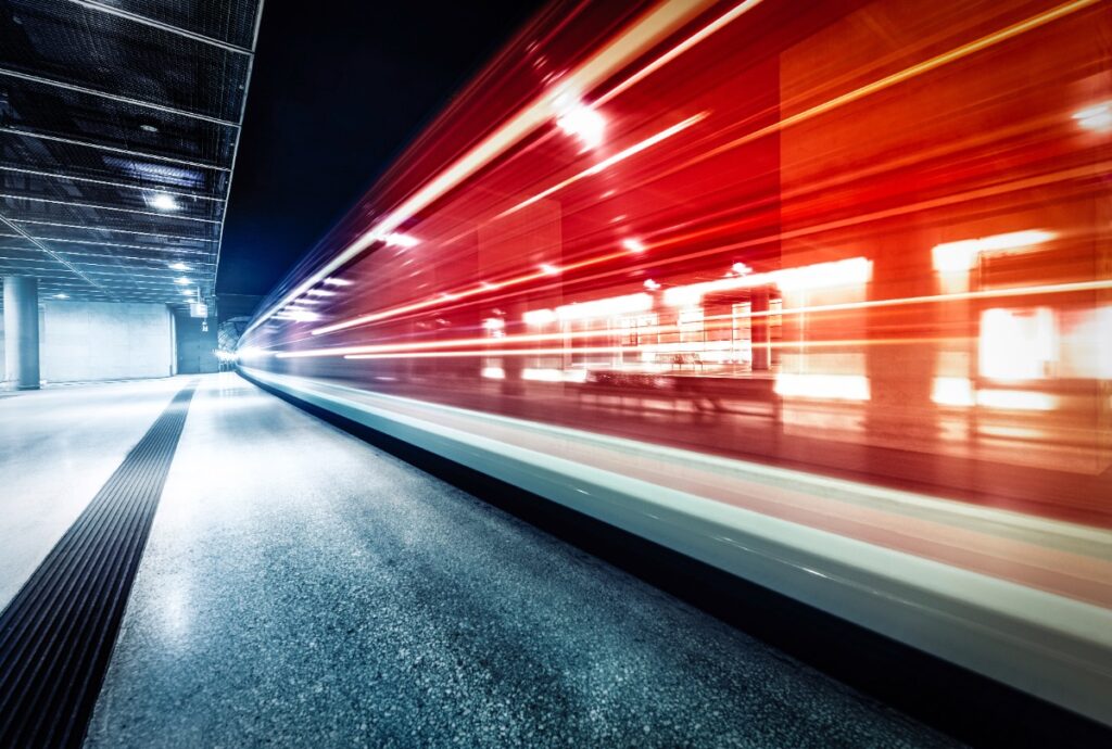 Deutsche Bahn: Wieder Preiserhöhung beim Deutschlandticket ab 2027 Ein roter Zug rast am Bahnsteig vorbei in der Nacht