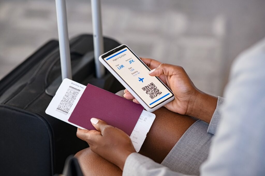 Thailand: Neue Einreisebestimmungen für ausländische Urlauber Hände einer Frau mit Gepäck halten am Flughafen Reisedokumente in der Hand