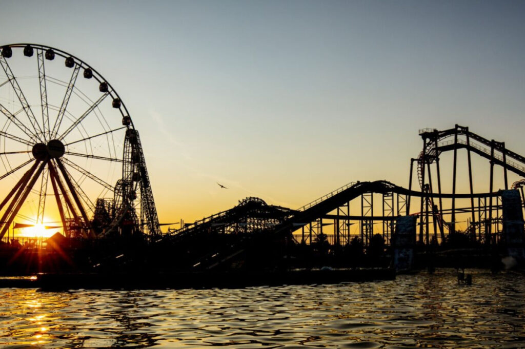 Energylandia: Höchster Wing Coaster der Welt kommt 2027 nach Polen Freizeitpark Energylandia bei Sonnenuntergang und Abendstimmung mit Riesenrad- und Achterbahnen-Silhouette