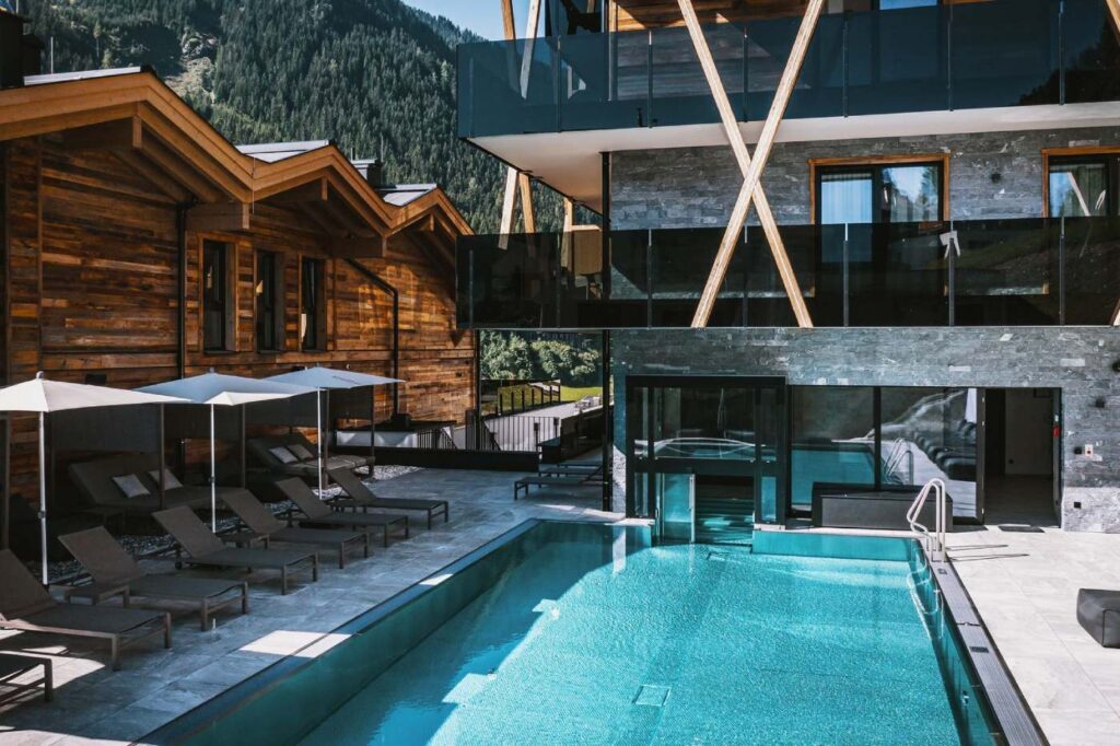 Alpen-Auszeit im Glemmtal: 3 Nächte im Superior-Resort mit Bergblick und Suite-Upgrade (limitiert) ab 255 Euro GLEMM by AvenidA Hotel Ansicht mit Außenpool
