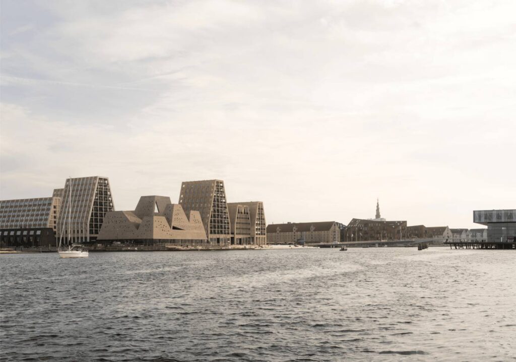 Kopenhagen bekommt neues Wahrzeichen am Hafen: KAI eröffnet im Dezember 2026 Futuristisches Gebäude aus Backstein am Kopenhagener Hafen. Zwischen mehreren Backsteintürmen verbergen sich insgesamt zehn indoor- und outpoor-Pools und Kulturräume