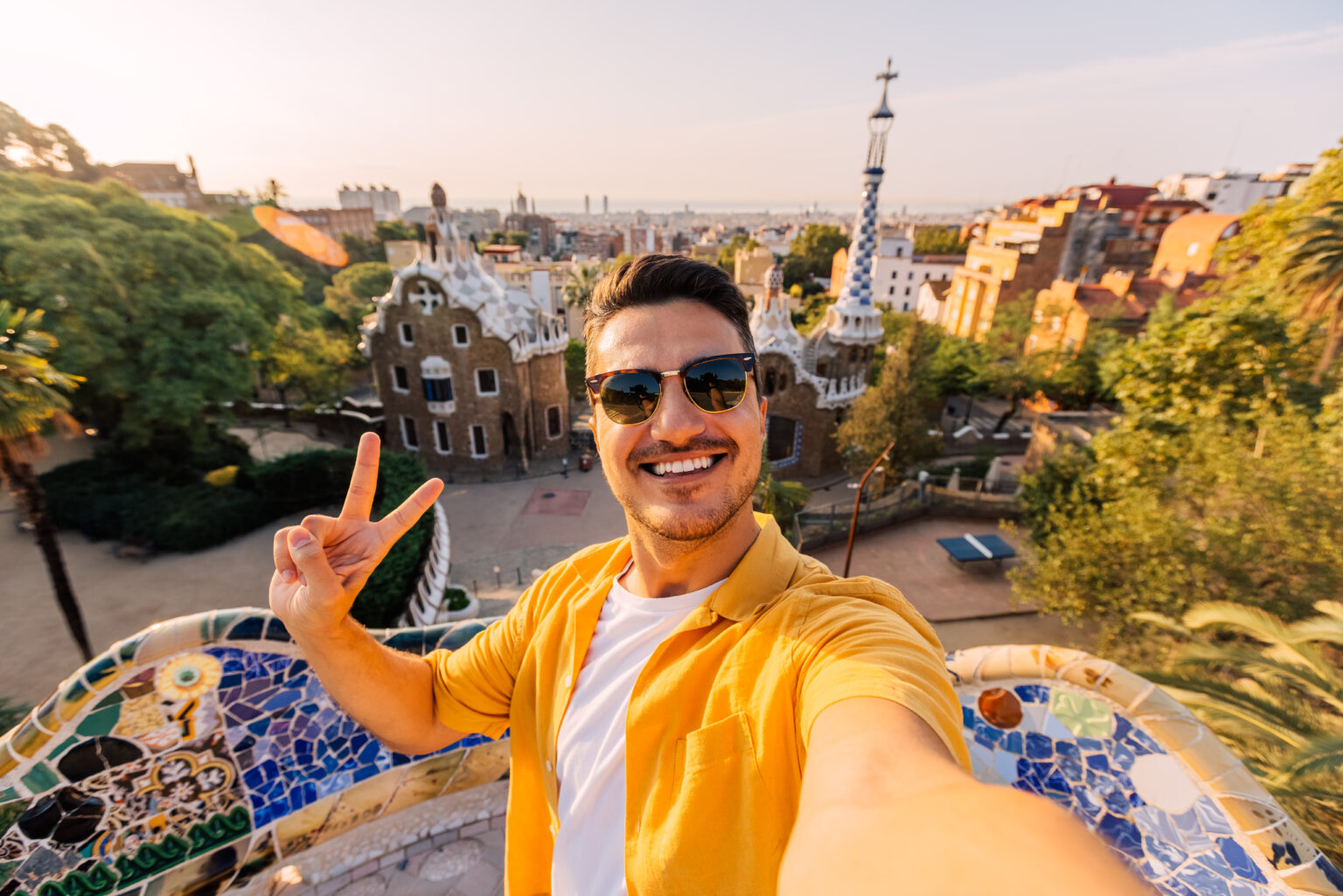 Studie: Portugiesen posten die meisten Urlaubs-Selfies in Europa Selfie von einem jungen Mann mit Sonnenbrille im Park Güell vor der Skyline Barcelonas