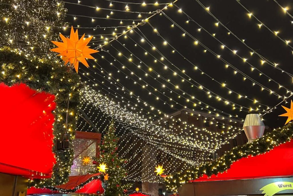 Santa Weihnachtsmarkt in Köln 2026: Neue Attraktion im MediaPark öffnet zum ersten Mal Schöner Weihnachtsschmuk mit gelbem Stern und Sternenzelt auf einem Weihnachtsmarkt in Köln